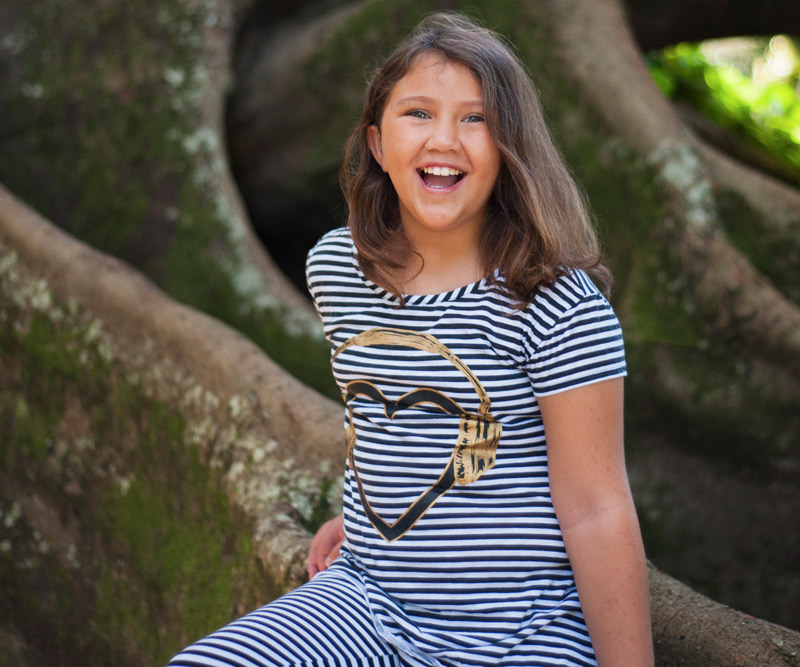 Lily Faith Lyman sitting on branch of a tree